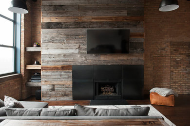Photo of an industrial family room in Chicago with a metal fireplace surround.