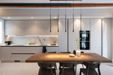 Design ideas for a medium sized scandinavian single-wall open plan kitchen in Barcelona with a submerged sink, flat-panel cabinets, grey cabinets, engineered stone countertops, metallic splashback, engineered quartz splashback, black appliances, porcelain flooring, no island, grey floors, white worktops and exposed beams.