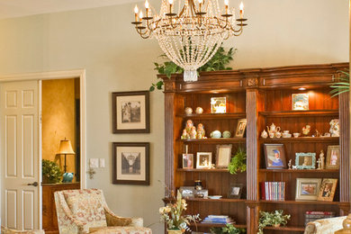 Example of a large classic open concept medium tone wood floor and brown floor living room library design in Miami with beige walls, no fireplace and no tv