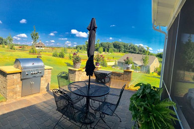 Example of a mid-sized minimalist backyard concrete paver patio kitchen design in Charlotte