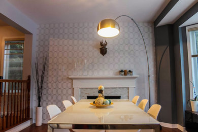 Kitchen/dining room combo - large contemporary medium tone wood floor kitchen/dining room combo idea in Ottawa with gray walls, a standard fireplace and a wood fireplace surround
