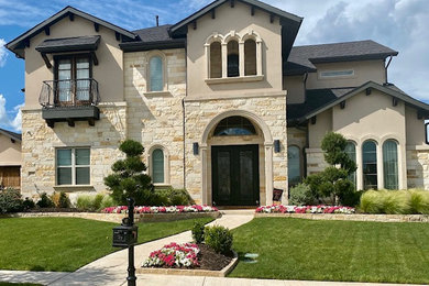 Large mediterranean beige two-story stone exterior home idea in Dallas with a shingle roof and a black roof