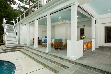 Large stone screened-in back porch idea in DC Metro with a roof extension