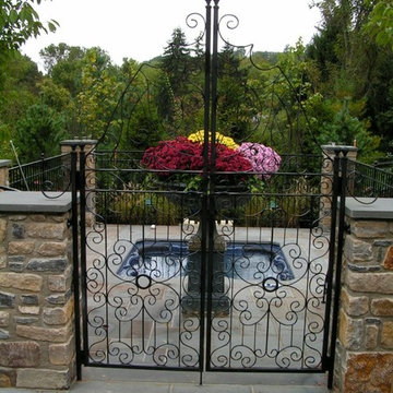 In-ground spa with wrought iron railing and columns.