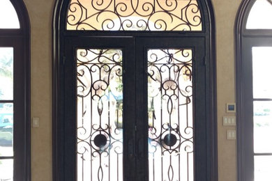 Imagen de puerta principal mediterránea grande con paredes beige, suelo de baldosas de cerámica, puerta doble, puerta metalizada y suelo beige