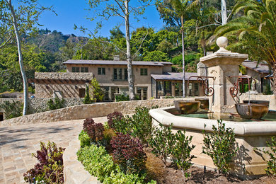 This is an example of a mediterranean front yard water fountain landscape in Los Angeles.