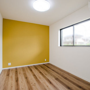 Nordisk inredning av ett pojkrum kombinerat med skrivbord och för 4-10-åringar, med gula väggar, mellanmörkt trägolv och brunt golv