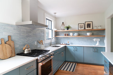 Mid-sized modern galley eat-in kitchen in Charleston with an undermount sink, flat-panel cabinets, blue cabinets, quartz benchtops, blue splashback, ceramic splashback, stainless steel appliances, with island and white benchtop.