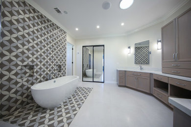 Photo of an expansive modern master bathroom in Los Angeles with raised-panel cabinets, medium wood cabinets, a freestanding tub, a one-piece toilet, brown tile, porcelain tile, white walls, porcelain floors, a drop-in sink, marble benchtops, white floor, white benchtops, a double vanity, a built-in vanity, an open shower and an open shower.