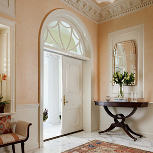 マイアミの大きい両開きドアトラディショナルスタイルのおしゃれな玄関ロビー (オレンジの壁、大理石の床、白いドア、グレーの床) の写真