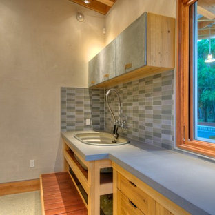 タンパの中サイズのカントリー風おしゃれな洗濯室 (コンクリートカウンター、コンクリートの床、スロップシンク、フラットパネル扉のキャビネット、中間色木目調キャビネット、グレーのキッチンカウンター) の写真