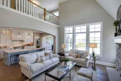 Inspiration for a large transitional open concept medium tone wood floor and brown floor living room remodel in Other with beige walls, a standard fireplace, a stone fireplace and no tv
