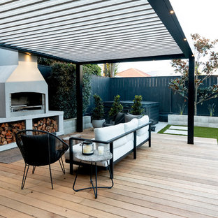 オークランドの大きいコンテンポラリースタイルのおしゃれな裏庭のデッキ (アウトドアキッチン、張り出し屋根) の写真