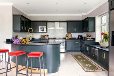 ロンドンにある高級な広いエクレクティックスタイルのおしゃれなキッチン (緑のキャビネット、御影石カウンター、白いキッチンパネル、磁器タイルのキッチンパネル、黒いキッチンカウンター) の写真