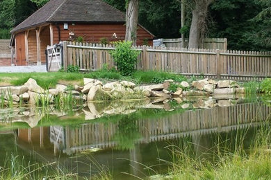 This is an example of a traditional backyard garden in Other with with pond.
