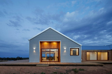Inspiration for a mid-sized country one-storey exterior in Melbourne with metal siding.