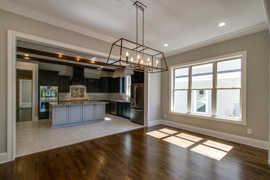 Mid-sized transitional l-shaped ceramic tile and white floor open concept kitchen photo in Other with an undermount sink, raised-panel cabinets, brown cabinets, granite countertops, white backsplash, ceramic backsplash, stainless steel appliances and an island
