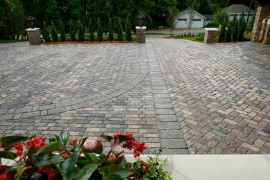 This is an example of a large front yard full sun driveway for summer in Minneapolis with brick pavers.