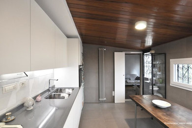 Idéer för att renovera ett avskilt, litet funkis linjärt kök, med en undermonterad diskho, släta luckor, vita skåp, bänkskiva i kvarts, rostfria vitvaror, klinkergolv i porslin och brunt golv