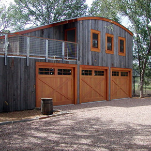 This is an example of a large eclectic attached three-car garage in Austin.