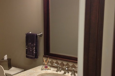 Imagen de aseo tradicional pequeño con lavabo bajoencimera, puertas de armario de madera en tonos medios, encimera de granito, sanitario de dos piezas y paredes grises