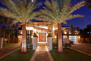 Tropical two-story stone exterior home idea in Miami