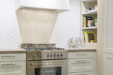 Example of a mid-sized transitional l-shaped slate floor and blue floor eat-in kitchen design in Toronto with shaker cabinets, white cabinets, quartzite countertops, white backsplash, ceramic backsplash, stainless steel appliances, no island and an undermount sink