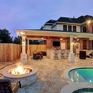 Mid-sized traditional backyard patio in Houston with an outdoor kitchen, tile and a roof extension.