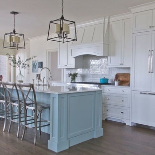 Design ideas for a large traditional galley kitchen pantry in Atlanta with a farmhouse sink, shaker cabinets, blue cabinets, quartz benchtops, white splashback, glass tile splashback, stainless steel appliances, dark hardwood floors and with island.