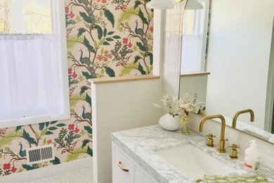 Mid-sized white tile and ceramic tile terrazzo floor and white floor powder room photo with flat-panel cabinets, white cabinets, white walls, an undermount sink, marble countertops, white countertops and a freestanding vanity
