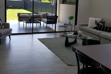 Trendy formal and enclosed porcelain tile and gray floor living room photo in Vancouver with white walls, a tv stand, a hanging fireplace and a stone fireplace