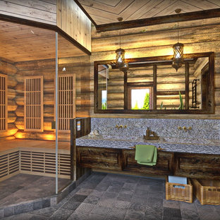 Idée de décoration pour un grand WC et toilettes chalet avec un placard avec porte à panneau surélevé, des portes de placard marrons, un mur beige, un sol en carrelage de porcelaine, un lavabo intégré, un plan de toilette en surface solide, un sol gris, un plan de toilette gris et un bidet.