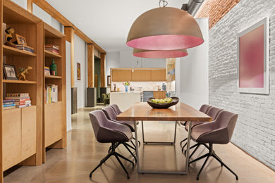 Example of a mid-sized mid-century modern concrete floor, gray floor and brick wall great room design in New York with white walls and no fireplace