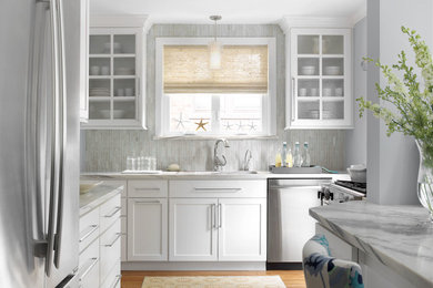 Inspiration for a coastal medium tone wood floor kitchen remodel in St Louis with an undermount sink, shaker cabinets, white cabinets, gray backsplash, stainless steel appliances, marble countertops and matchstick tile backsplash