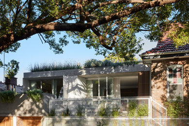 Photo of a mid-sized three-storey concrete house exterior in Sydney with a flat roof.