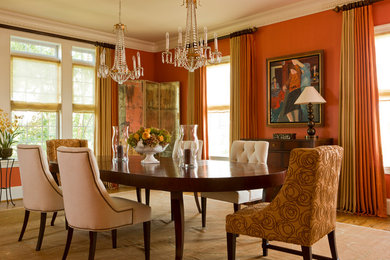 Example of a classic medium tone wood floor dining room design in DC Metro with orange walls