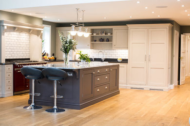 Inspiration for an arts and crafts kitchen in Surrey with a farmhouse sink, shaker cabinets, white splashback, subway tile splashback, coloured appliances and medium hardwood floors.