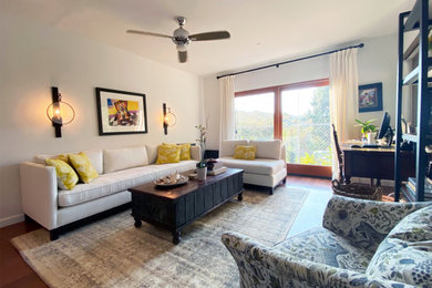 Abgetrenntes Wohnzimmer mit weißer Wandfarbe, braunem Holzboden und braunem Boden in Los Angeles