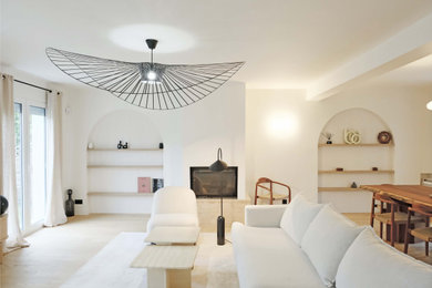 Exemple d'un grand salon tendance ouvert avec un mur blanc, parquet clair, une cheminée standard, un manteau de cheminée en plâtre, un téléviseur fixé au mur et un sol beige.