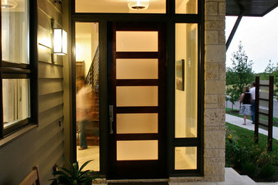 This is an example of a mid-sized contemporary front door in Austin with a single front door, a dark wood front door and beige walls.