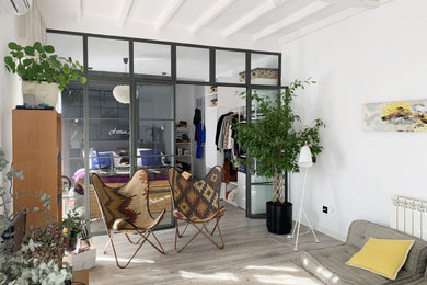 Foto de salón tipo loft bohemio pequeño con paredes blancas, suelo de madera clara, suelo gris y vigas vistas
