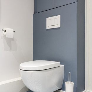 Esempio di un piccolo bagno di servizio moderno con ante a filo, ante grigie, WC sospeso, pareti grigie, pavimento in cementine, pavimento grigio e top bianco