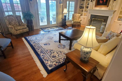 Living room - large traditional formal and enclosed medium tone wood floor, brown floor, wallpaper ceiling and brick wall living room idea in Other with yellow walls, a standard fireplace, a concrete fireplace and no tv