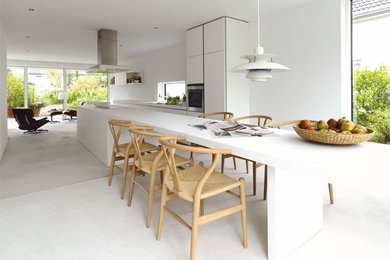 Photo of a large scandinavian single-wall eat-in kitchen in Gothenburg with flat-panel cabinets, white cabinets, laminate benchtops, stainless steel appliances, concrete floors and with island.