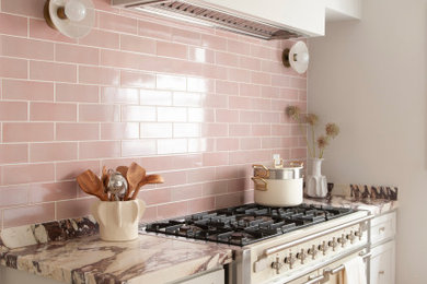 Kitchen - transitional medium tone wood floor and brown floor kitchen idea in Los Angeles with shaker cabinets, white cabinets, pink backsplash, white appliances and multicolored countertops