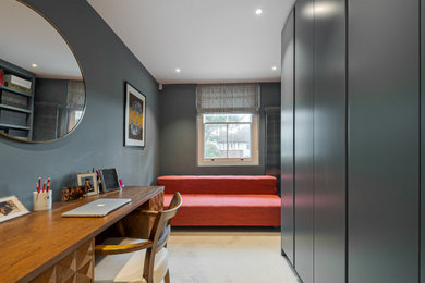 Photo of a contemporary study in London with blue walls, carpet and a freestanding desk.