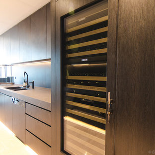 Exemple d'une grande arrière-cuisine parallèle moderne avec un évier encastré, un placard à porte plane, des portes de placard en bois sombre, un plan de travail en carrelage, une crédence grise, une crédence en carreau de porcelaine, un électroménager noir, un sol en carrelage de porcelaine, aucun îlot, un sol beige et un plan de travail gris.