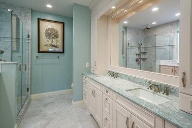 Large master blue tile marble floor corner shower photo in Philadelphia with a drop-in sink, raised-panel cabinets, beige cabinets, marble countertops and blue walls