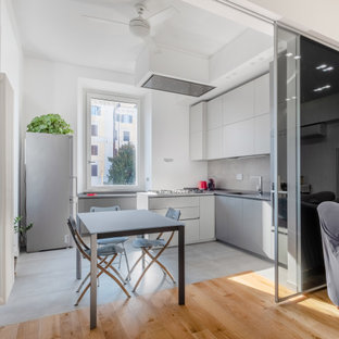 Ispirazione per un'ampia cucina design con lavello sottopiano, ante lisce, ante grigie, top in marmo, paraspruzzi grigio, paraspruzzi in gres porcellanato, elettrodomestici neri, pavimento in gres porcellanato, penisola, pavimento grigio, top grigio e soffitto ribassato