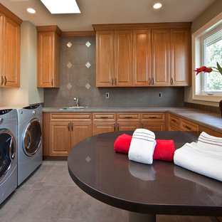 This is an example of a large traditional u-shaped separated utility room in Seattle with raised-panel cabinets, medium wood cabinets, a side by side washer and dryer, a built-in sink, grey floors, concrete worktops, beige walls, concrete flooring and grey worktops.